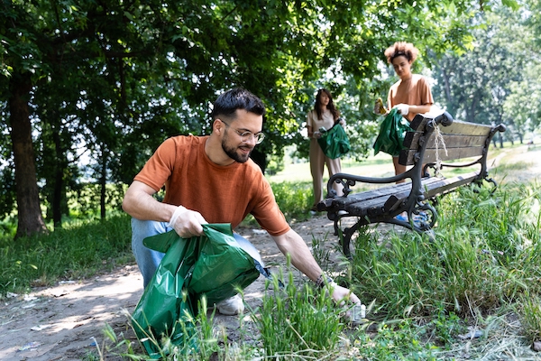 Young,Volunteers,Cleaning,Up,Park,Together,,Collecting,Trash,And,Holding